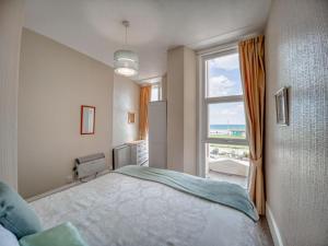 a bedroom with a bed and a large window at Apartment 2 - 1 Bedroom Sea Front-Sea Views-Free Parking in Paignton
