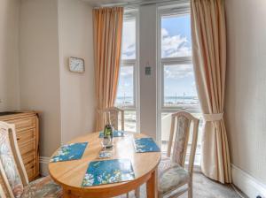 a dining room with a table and chairs and a window at Apartment 2 - 1 Bedroom Sea Front-Sea Views-Free Parking in Paignton