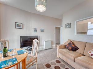 a living room with a couch and a table at Apartment 2 - 1 Bedroom Sea Front-Sea Views-Free Parking in Paignton