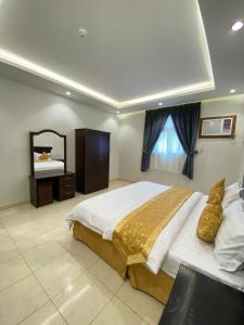 a bedroom with a large bed and a mirror at أركانا للشقق المخدومة in Tabuk