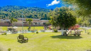 un parque con banco y parque infantil en Hotel Nascentes da Serra, en Poços de Caldas