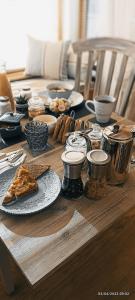 a wooden table topped with plates of food and pizza at Outlander Boutique B&B Super King in Cruden Bay
