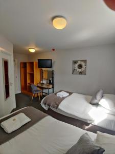 a hotel room with two beds and a desk at Woolpack Inn in Chichester