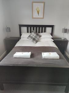 a large bed with two white towels on it at Woolpack Inn in Chichester