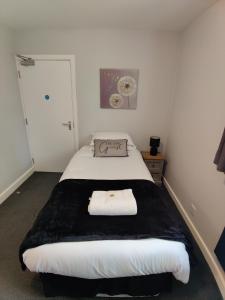 a bedroom with a bed with a black and white blanket at Woolpack Inn in Chichester