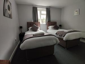 two beds sitting in a room with a window at Woolpack Inn in Chichester