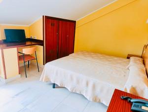 1 dormitorio con 1 cama y escritorio con ordenador en Hotel Alameda, en Villaviciosa