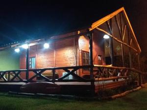 a wooden cabin at night with lights on it at Cabaña La Justina in San José