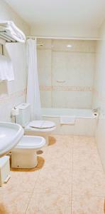 a bathroom with two toilets and a bath tub at Hotel Alameda in Villaviciosa
