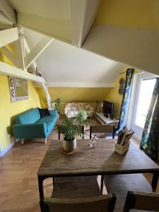 een woonkamer met een blauwe bank en een tafel bij A la bon'Eure in Nassandres