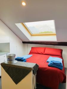 a bedroom with a red bed with a skylight at Lecco Centro 1 in Lecco