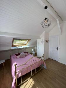 a bedroom with a bed with a pink bedspread at A la bon'Eure in Nassandres