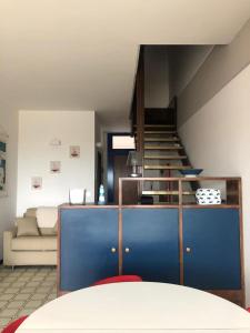 リド・ディ・イエゾロにあるRESIDENCE PENELOPE - WALTERIGATO Apartments SOLO PER FAMIGLIEのリビングルーム(青いキャビネット、階段付)