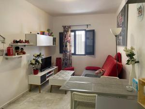 Una pequeña sala de estar con una mesa y un sofá. en APARTAMENTO Centro ciudad, en Jerez de la Frontera