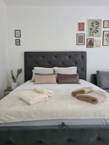 a bed with two blankets and pillows on it at Apartman Rosemary in Sveti Stefan