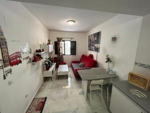 ein Wohnzimmer mit einem roten Sofa und einem Tisch in der Unterkunft APARTAMENTO Centro ciudad in Jerez de la Frontera