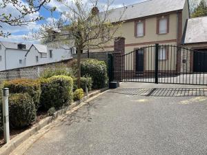 a fence in front of a house with a driveway at Beautiful ground floor 2 bedroom apartment in Honfleur