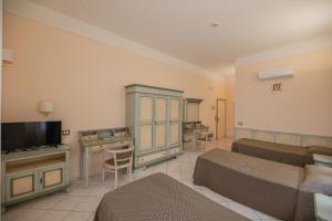 un soggiorno con 2 letti e una TV di Villa Santa Margherita - B&B a Cortona