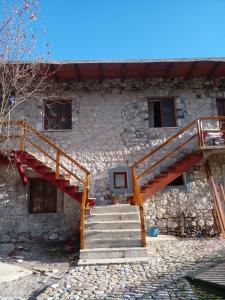 a stone house with stairs leading to a building at GUEST HOUSE “ Center Theth “ in Theth