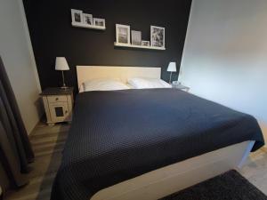 1 dormitorio con 1 cama con sábanas negras y almohadas blancas en Harzfeuer Zentrum, en Bad Harzburg