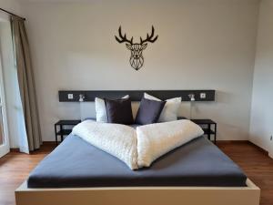 a bedroom with a bed with a deer head on the wall at Ferienwohnung Zauberwinkelweg mit Traum-Aussicht! in Wildschönau
