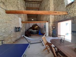 a dining room with a table and chairs in a stone wall at Le gîte de Sainte Valière PISCINE,SPA et CLIMATISATION in Sainte-Vallière