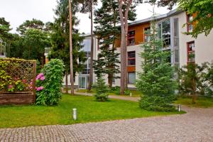 a building with a garden in front of it at Zielona Przystań BlueApart Jurata in Jurata