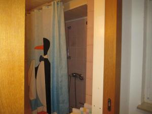 a bathroom with a shower with a penguin on the shower curtain at Alsfelder Apartment I in Alsfeld +14 photos