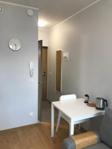 ein Wohnzimmer mit einem weißen Tisch und einem Stuhl in der Unterkunft Pepleri Studio 20 in Tartu