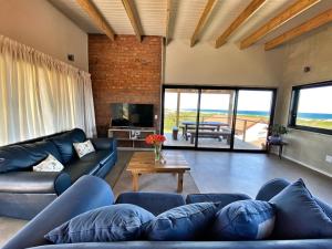 un soggiorno con divani blu e TV di A Real Gem in Cape St Francis a Cape St Francis