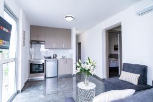 cocina y sala de estar con sofá y mesa en Spiros Luxury Apartments, en Ayia Napa