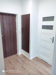 a room with two doors and a wooden floor at Apartament Anastazja in Koszalin