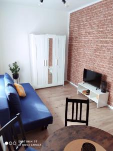 sala de estar con sofá azul y TV en Apartament Anastazja en Koszalin