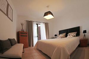 a bedroom with a bed and a couch and a chair at ML Carvoeiro Mar Apartment in Carvoeiro