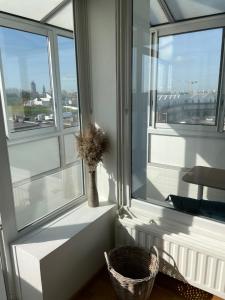 Cette chambre dispose d'une fenêtre avec un vase de fleurs. dans l'établissement Très bel appartement vue Mer - Les Ilots bleus - Dunkerque Malo les Bains, à Dunkerque