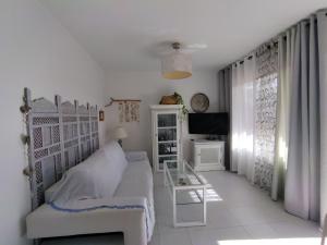 コラレホにあるCasa Dan "Residencial Las Dunas"の白いベッドルーム(ベッド1台、テレビ付)