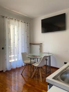 comedor con mesa, sillas y fregadero en Appartamento Aurelia, en Molina di Ledro