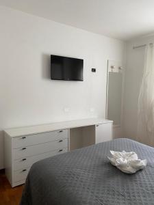 1 dormitorio con 1 cama, escritorio y TV en Appartamento Aurelia, en Molina di Ledro