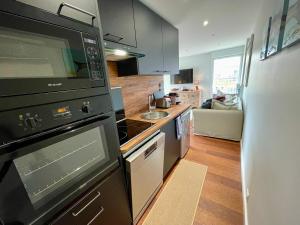 a kitchen with a stove and a microwave at Au Phare du Cap in Cap-Ferret