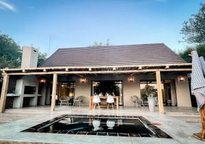 een huis met een zwembad ervoor bij UmnDeni Africa in Hoedspruit
