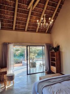 a bedroom with a bed and a view of a patio at UmnDeni Africa in Hoedspruit +77 photos