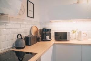 eine Küche mit einer Theke mit einer Mikrowelle und Geräten in der Unterkunft HYGG INN Ferienhaus in Heiligendamm