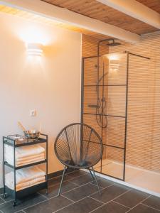 ein Bad mit einer Dusche und einem Stuhl in der Unterkunft HYGG INN Ferienhaus in Heiligendamm