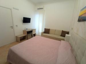een hotelkamer met een bed en een bank bij B&B Casa Denittis in Peschici