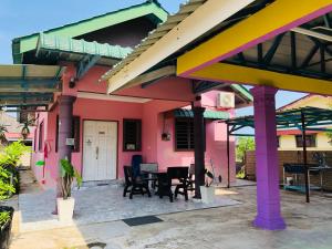 ein farbenfrohes Haus mit einem Tisch und Stühlen in der Unterkunft Homestay TokAbah in Pasir Puteh
