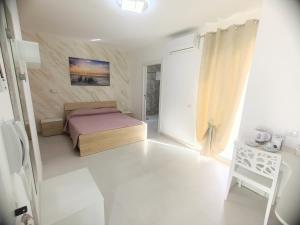um pequeno quarto com uma cama e uma mesa em B&B Casa Denittis em Peschici