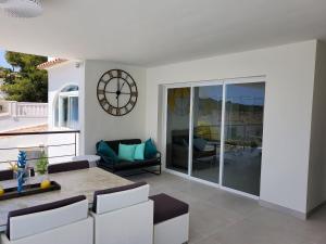 a living room with a clock on the wall at Villa Blue Lagoon Moraira in Moraira