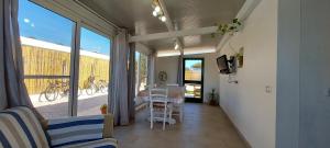 een woonkamer met een tafel, stoelen en ramen bij Casa da Gino in Calasetta