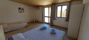 a room with two beds and a table with shoes on it at Casa da Gino in Calasetta