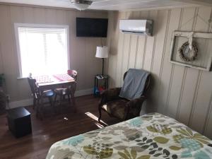 a bedroom with a bed and a table and chairs at Lakeshore Fishing Cabin #3, Ramp, dock, fire pit in Lake Ozark
